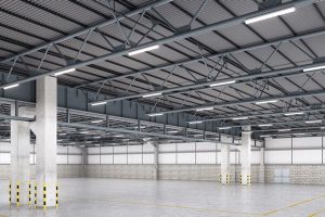 batten-fixture-warehouse Warehouse with rows of shelves and storage racks lit by energy saving LED batten. Bright and uniform lighting for better visibility. Safe and productive working environment. Fixtures mounted on ceiling for easy navigation and locating of items.